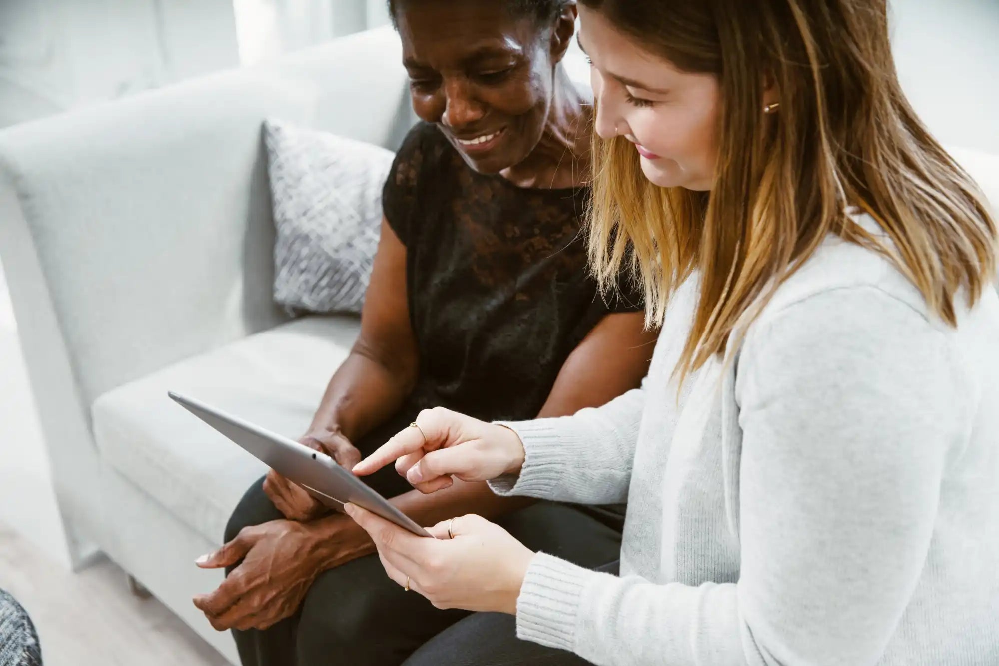 Two women looking at a tablet.